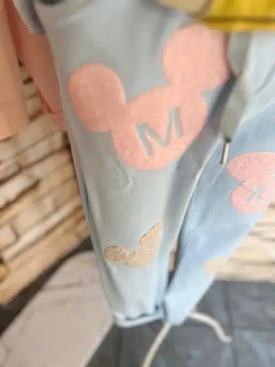 Hol dir den Look: Die "Mickey Pastel" Jogpants in Hellblau mit stylischen pink-beigen Mickey-Patches und coolem "M"-Detail!.