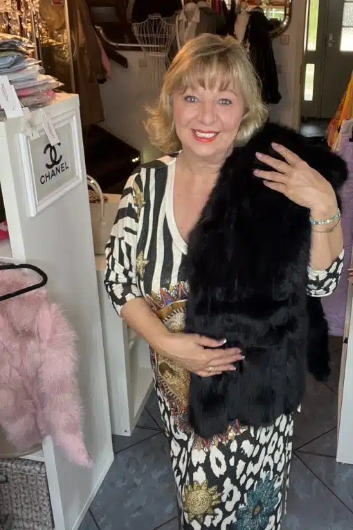 Entdecke deinen Look: Du strahlst in deinem gemusterten Kleid und setzt mit dem schwarzen Felltraum Poncho Schal Trends!.