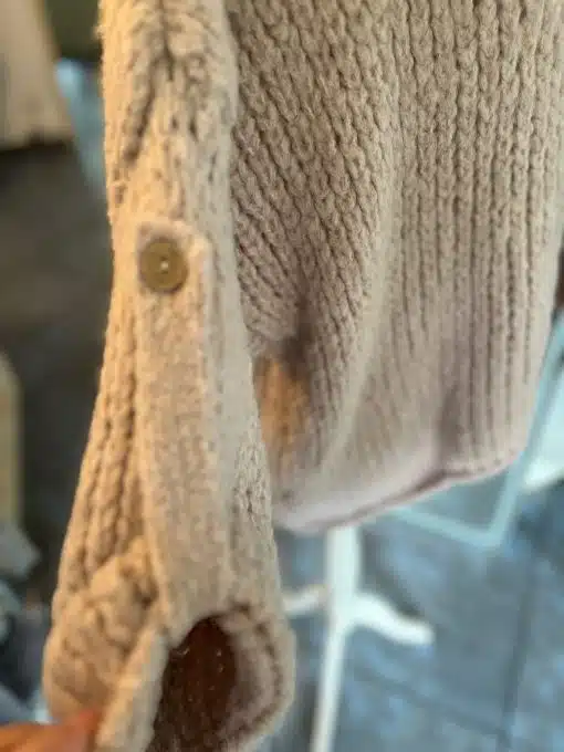 Erlebe den Kuschel Pulli in Beige - spüre das ultra-softe Strickmuster und entdecke das stylishe Knopfdetail am Ärmel.