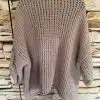 Hol dir den ultimativen Kuschel Pulli in Beige - modern, superweich und stylisch vor rustikaler Steinwand präsentiert!.