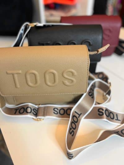 Entdecke die "Toos" Schultertasche in Beige, Schwarz oder Bordeaux - stylisch mit TOOS-Schriftzug auf den modernen Trägern.
