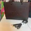 Entdecke deine neue braune "Toos" Handtasche mit geprägtem Logo und abnehmbarem Riemen - dein modernes Must-have!.