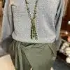 Du trägst den Chic Fur Touch Pulli, stylische olivgrüne Wickelhose und eine lange, moderne grüne Perlenkette - ein echter Eyecatcher!.