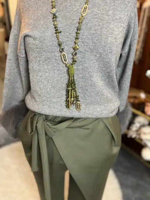 Du trägst den Chic Fur Touch Pulli, stylische olivgrüne Wickelhose und eine lange, moderne grüne Perlenkette - ein echter Eyecatcher!.
