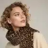 Mit dem "Leopard Luxe Kragenschal" und beigen Sweater setzt du mit deinen Locken ein stylisches Statement - trau dich, hinzuschauen!.