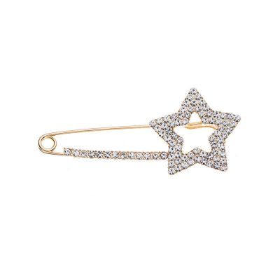 Hol dir den angesagten Look: Diese goldene Ponchonadel mit funkelndem Kristallstern-Highlight verleiht deinem Outfit Glamour!.