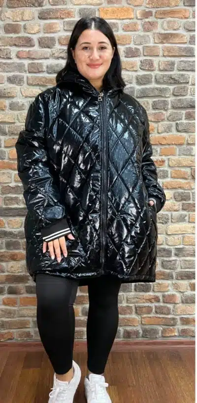 Präsentiere dich stylisch: Im Glossy Oversize Coat, schwarzen Leggings und weißen Sneakern rockst du die Backsteinwand!.
