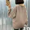 Du trägst den angesagten, übergroßen taupefarbenen Pullover und schwarze Leggings, stylisch beim Selfie aus cooler Perspektive.