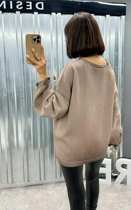Du trägst den angesagten, übergroßen taupefarbenen Pullover und schwarze Leggings, stylisch beim Selfie aus cooler Perspektive.