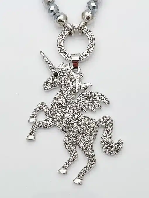 Entdecke deinen Jahreszeiten Wechsel Anhänger: Ein silbernes Einhorn mit funkelnden Steinen und Flügeln an moderner Perlenkette.