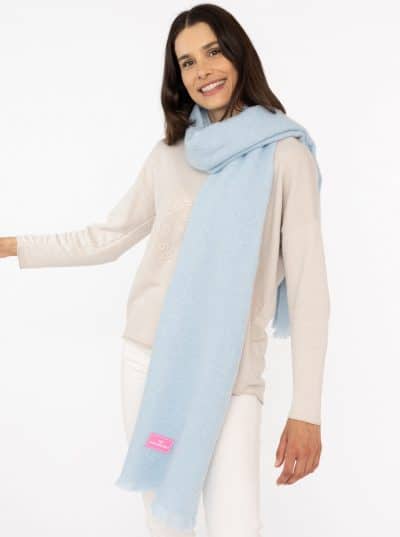 Du strahlst im Schal "Flauschig" in Hellblau - kombiniert mit beigem Pullover und weißen Hosen bist du der moderne Hingucker.