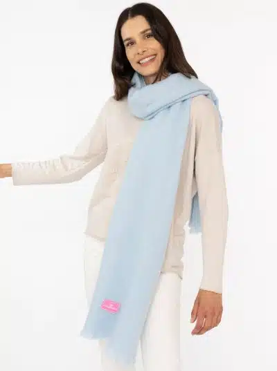 Du strahlst im Schal "Flauschig" in Hellblau - kombiniert mit beigem Pullover und weißen Hosen bist du der moderne Hingucker.