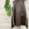Du hängst Urban Chic an die Wand: Die braune Kunstleder-Weste mit weißem Fellfutter neben grünen Pflanzen - stylisch und modern!.