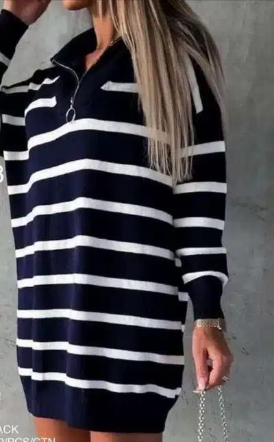 Du trägst ein modernes, langärmeliges Strickkleid mit schwarz-weißen Streifen und Zipper-Kragen, dazu deine Chain-Bag.