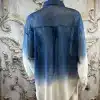 Entdecke die Crystal Ombre Bluse: Dein Fashion-Highlight mit blau-weißem Farbverlauf, perfekt inszeniert vor edlem Hintergrund.