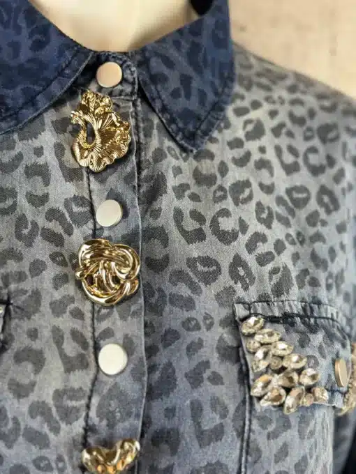 Setzen Sie ein Statement mit diesem modernen Leopardenhemd: Goldene Blumenknöpfe und funkelnde Schmuckdetails machen dich zum Star.