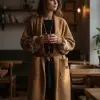 Genieße deinen Moment im Herzstück Long-Cardigan und halte stilvoll deinen Kaffee im modernen, gemütlich beleuchteten Café.