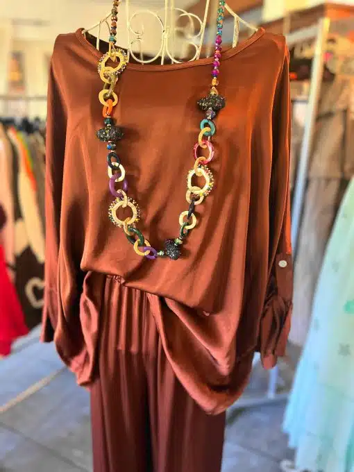 Entdecke deinen neuen Style: Der "Lounge Traum" 2-Teiler in Rost-Satin mit bunter Chunky-Kette wartet im Boutique-Regal auf dich!.