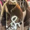 Erlebe den "Fashion Statement Mantel": Braune und beige Wolle mit weißen Mustern - dein Hingucker am stylischen Drahtbügel!.