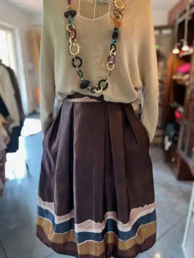 Zieh das beige Top, den gestreiften "Mara Midi"-Rock und die bunte Statement-Kette an - rock deinen modernen Chic!.