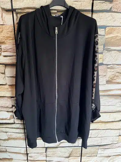 Hol dir den trendigen "Leo Glam XL Sweatjacke" Look mit angesagtem Leo-Muster an den Ärmeln - perfekt vor urbaner Backsteinwand.