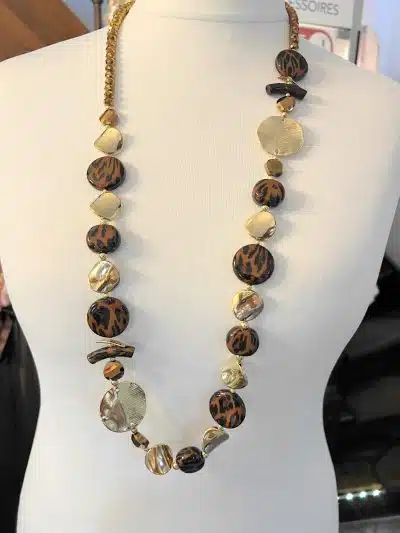 Entdecke deine neue Golden Jungle Statementkette - mit braunen, goldenen und cremefarbenen Perlen, modern präsentiert am Mannequin.