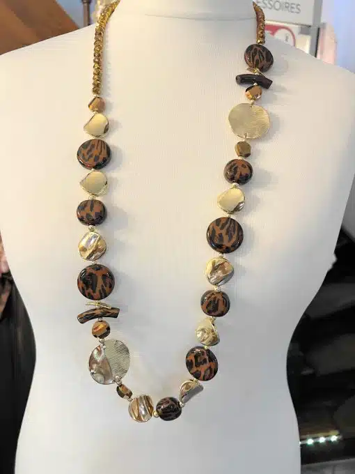 Entdecke deine neue Golden Jungle Statementkette - mit braunen, goldenen und cremefarbenen Perlen, modern präsentiert am Mannequin.