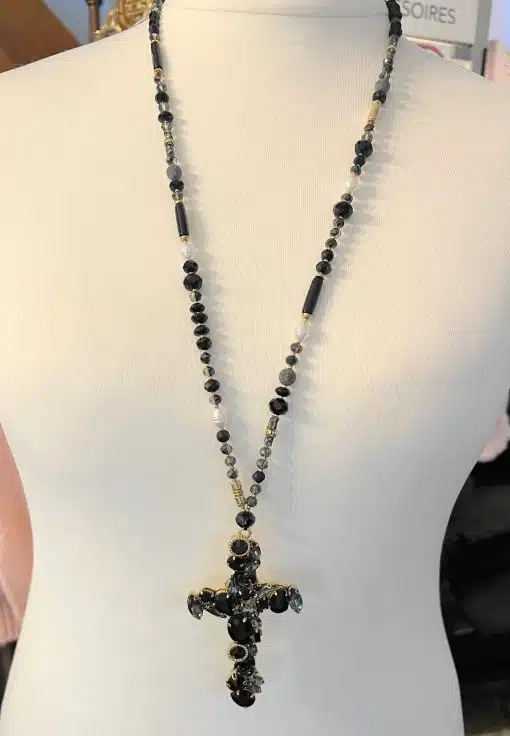 Setzen Sie mit der Eternal Shine Statementkette ein Fashion-Statement - schwarze Perlen, markantes Kreuz, präsentiert am weißen Torso.