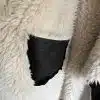 Erlebe das moderne Urban Chic Feeling: Kuschelig weißer Stoff trifft auf trendiges, schwarzes Leder-perfekt für deine Urban Chic Wendeweste.