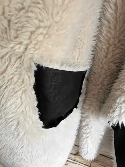 Erlebe das moderne Urban Chic Feeling: Kuschelig weißer Stoff trifft auf trendiges, schwarzes Leder-perfekt für deine Urban Chic Wendeweste.