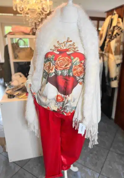 Tauche ein in den Trend: Rote Hose, weißer Flauschschal und Sweater mit Herz-Print - dazu der elegante Jolina Poncho Schal!.