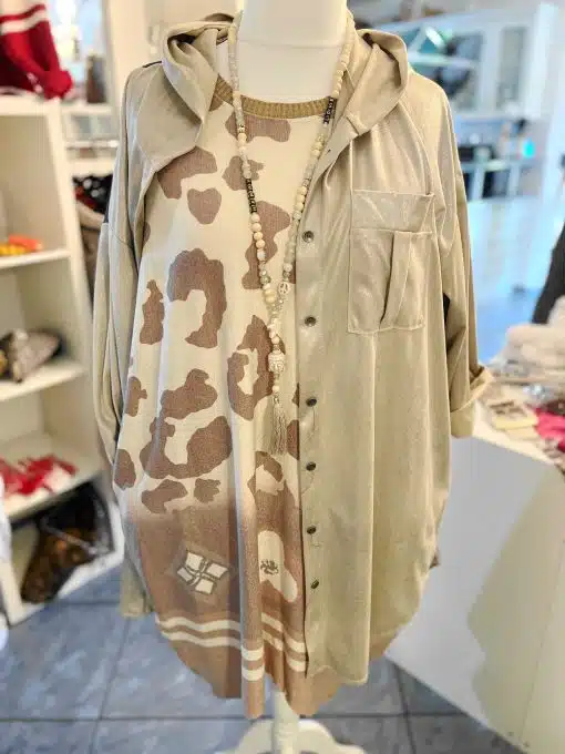 Du kombinierst ein beiges Hoodie-Shirt mit einem angesagten Animal-Print-Kleid und stylischer Perlenkette - bereit für den Trend!.