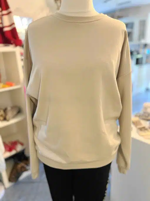 Zieh das Be Happy Sweatshirt an und setze ein Style-Statement - modern präsentiert an einer Schaufensterpuppe im trendigen Store.