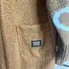 Entdecke deinen neuen Lieblingslook: Der braune Herzstück Long-Cardigan mit trendiger Struktur, Tasche und stylischem Label.