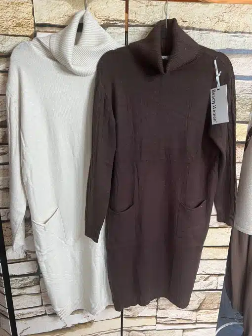 Entdecke deinen neuen Cozy-Look: Edle Strickkleider in Creme und Braun warten vor stylischer Steinwand auf dich!.