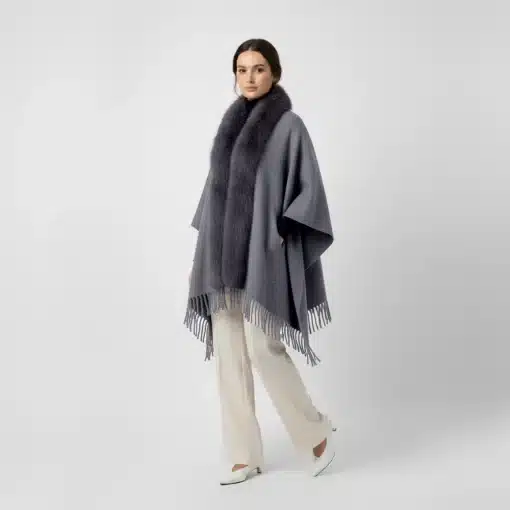 Trage den grauen Jolina Poncho Schal mit Fell und Fransen zu weißen Hosen und Heels - dein moderner Look für selbstbewusste Auftritte!.