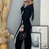 Entdecke deinen Style im Zweiteiler "Black & White Chic" mit schwarzer Tasche und Sonnenbrille vor moderner Kunst.