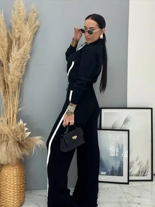 Entdecke deinen Style im Zweiteiler "Black & White Chic" mit schwarzer Tasche und Sonnenbrille vor moderner Kunst.