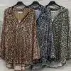 Entdecke deinen Look: drei angesagte Animal-Print-Blusen mit Pailletten in Braun, Grau und Grün - stylish am Holzpaneel präsentiert.