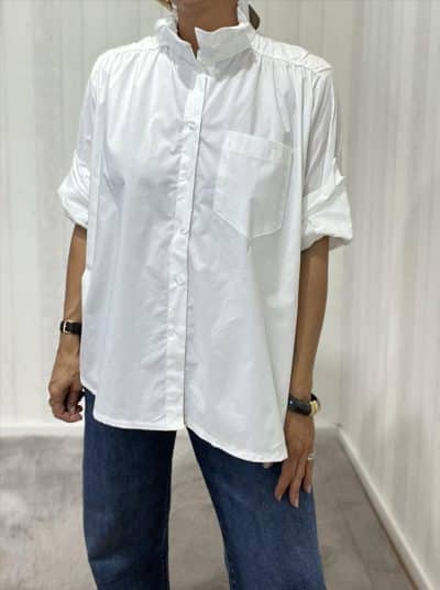 Du trägst die Everyday Cotton Blouse: lässig-weiße Baumwolle, modern gekrempelte Ärmel, kombiniert mit coolen Blue Jeans.