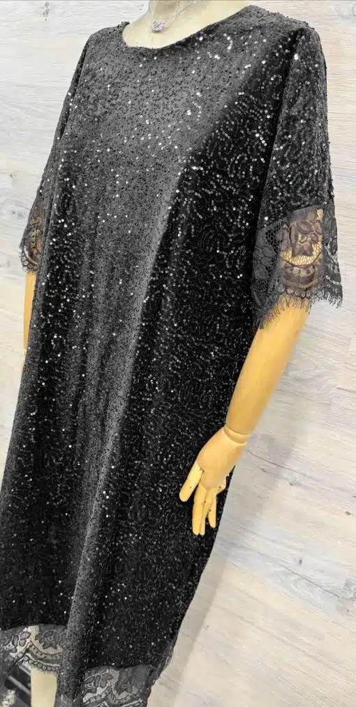 Glänze im Gala Shine Kleid - ein schwarzes Paillettenkleid mit Schleife, Spitze und Wow-Effekt auf hellem Holz-Hintergrund!.