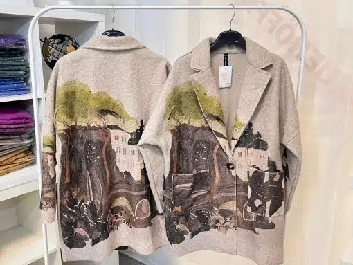 Entdecke deinen modernen Landhausstil: Zwei beige "Countryside Dream"-Blazer mit Landschaftsmotiv warten auf dich am Kleiderständer.