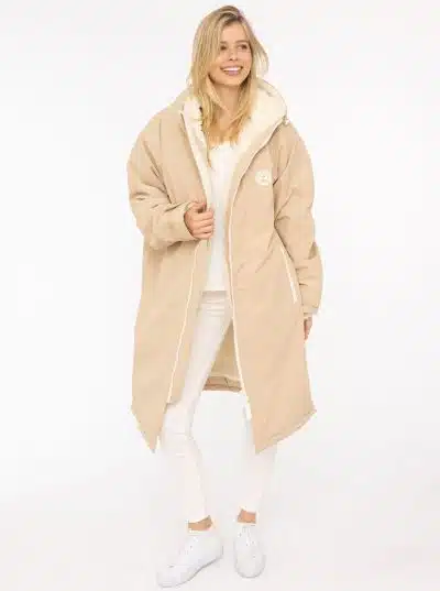 Strahle pure Leichtigkeit aus: Mit der beigen HerzWärmer Windjacke, weißer Hose und Sneakern setzt du ein modernes Statement.