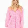 Strahle mit der pinken Sweatjacke "Leo Neon" von Zwillingsherz und weißen Pants - dein stylischer Look vor weißem Hintergrund.