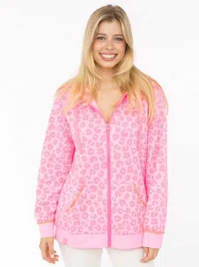 Strahle mit der pinken Sweatjacke "Leo Neon" von Zwillingsherz und weißen Pants - dein stylischer Look vor weißem Hintergrund.