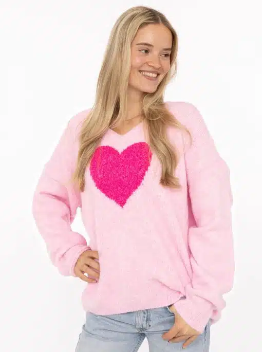 Du strahlst im Zwillingsherz Pullover "Love Affair" mit leuchtendem Pink-Herz zu hellblauen Jeans - modern, stylish und trendy.