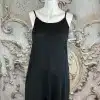Entdecke deinen modernen Style: Schwarzes Spaghettitop, elegant auf weißem Mannequin vor opulentem Vintage-Hintergrund.