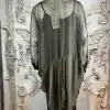 Entdecke deinen Look: Die transparente schwarze Bluse mit asymmetrischem Rücken bringt Glamour vor prachtvoller Kulisse.