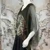 Entdecke deinen Look: Die "Wild Clash" Tunika - transparent, im Leo-Design, mit schwarzen Pants vor edlem Steinhintergrund.