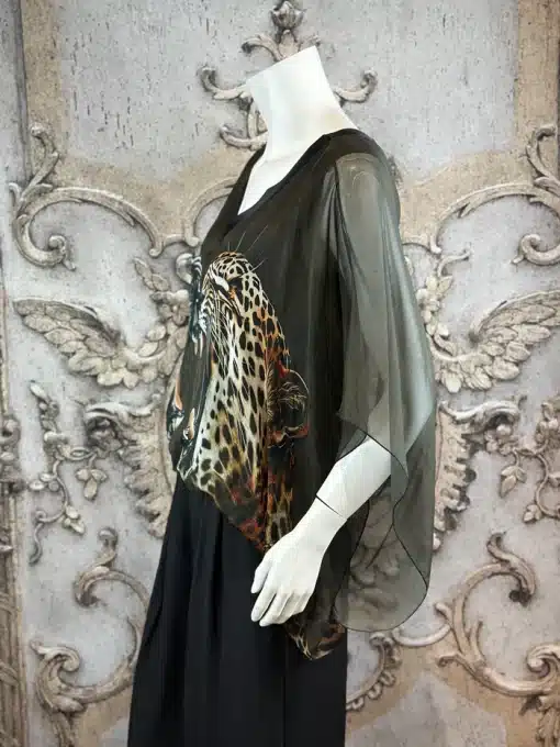 Entdecke deinen Look: Die "Wild Clash" Tunika - transparent, im Leo-Design, mit schwarzen Pants vor edlem Steinhintergrund.
